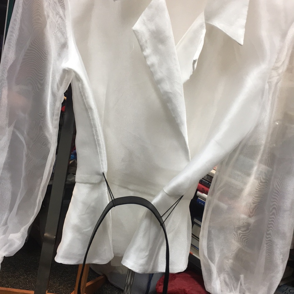 A top white shirt that has a belt included